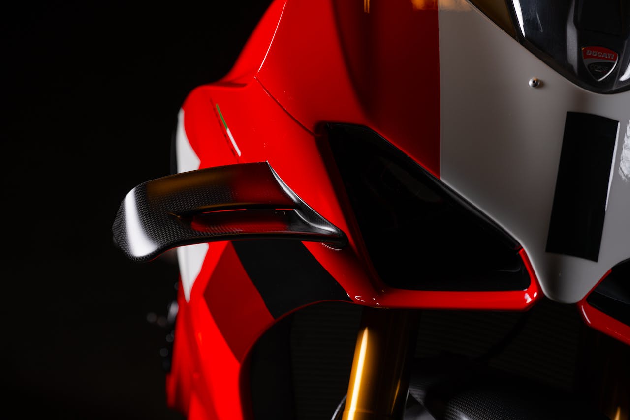 Close-up of a sleek red Ducati motorcycle captured at night with a focus on its aerodynamic design.